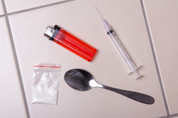 drug spuit, heroïne poeder in pakket, lepel en lichter op de - Foto, afbeelding