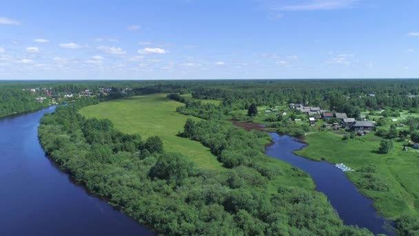Top view of green forest with rivers and village on background horizon with blue sky. Shot. Beautiful summer landscape with green forest and blue rivers - Footage, Video