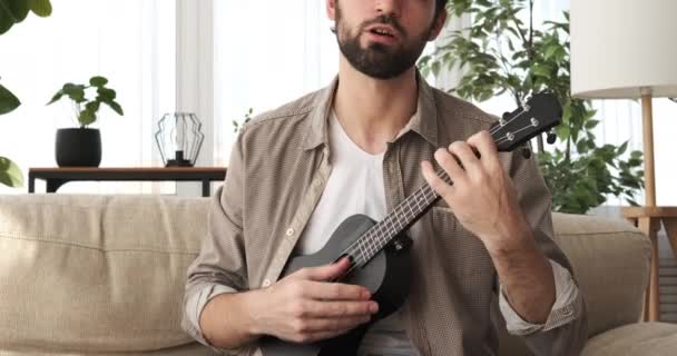 Man singing song and playing guitar at home - 映像、動画