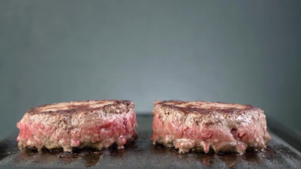Biftek köfteleri ızgarada pişiyor, az pişmiş sığır burger, yakın plan, fotokopi alanı. - Video, Çekim