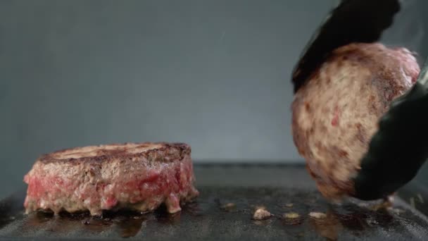 Marha hamburger főz a grillen, egy séf sült krumpli marhahús hamburger, közelkép - Felvétel, videó