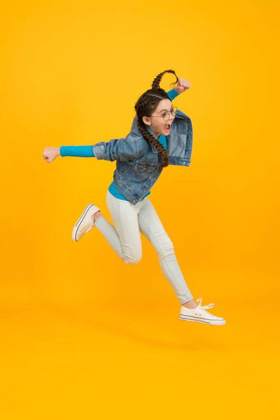 fly so high. kid having real fun. success in sport. happy winner child. teen girl jump on yellow background. This is a complete triumph. run to success. concept of childhood happiness - Φωτογραφία, εικόνα