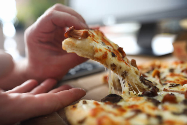 Erkek kolları büyük bir dilim taze pizza alıyor. - Fotoğraf, Görsel