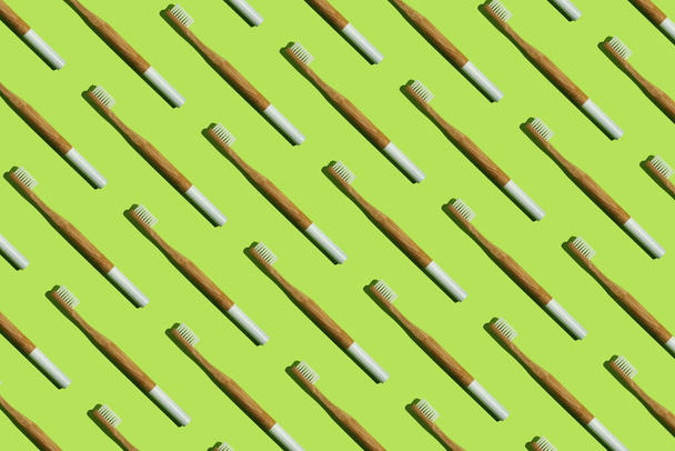 Bamboo toothbrushes on green background - Foto, imagen