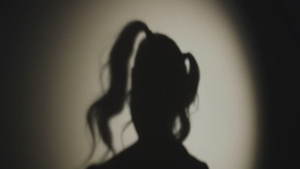 Tatort. Schatten des seltsamen Mörders einer jungen Frau mit Messer. Dunkle Silhouette auf weißem Hintergrund - Filmmaterial, Video
