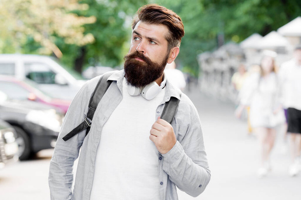 Discover local showplace. Backpack for urban traveling. Hipster backpack urban street background. Tourism and backpacking. Vacation concept. Modern rest. Bearded man travel. Guy exploring city - Photo, image