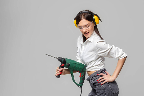 sexy Builder girl holding a drill. concept of advertising Housewives, work tools and construction-related works... - Photo, image