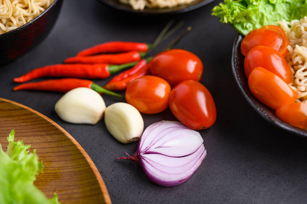Φωτεινό κοντινό φόντο από φέτες κόκκινου κρεμμυδιού, σκόρδο, ντομάτα και πιπεριές. Επιλεκτική εστίαση - Φωτογραφία, εικόνα