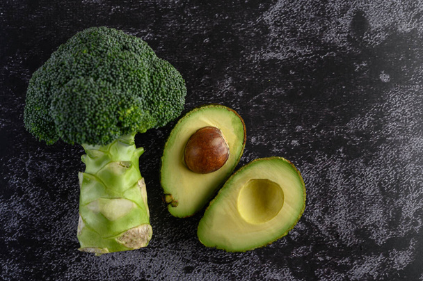 broccoli and avocado on a black cement floor background. - Photo, Image
