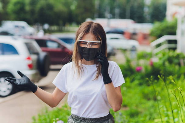 Portrait happy woman wile wearing a face shield for protection from cold and flu and viruses. Young woman with face mask in the street. Woman wearing face mask because of air pollution in the city. - Φωτογραφία, εικόνα