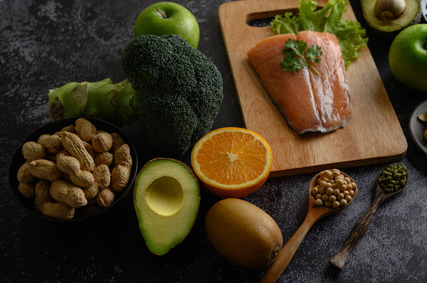 legumes, fruit, and Salmon fish pieces on a wooden chopping board. - Photo, Image