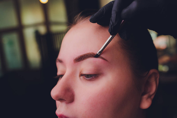 Make-Up. Beautician Hands Doing Eyebrow Tattoo On Woman Face.Permanent Brow Makeup In Beauty Salon. Closeup Of Specialist Doing Eyebrow Tattooing For Female. Cosmetology Treatment. - Fotoğraf, Görsel