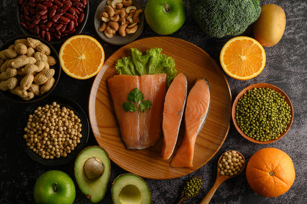 Legumes, fruit and salmon pieces on a wooden plate. - Photo, Image