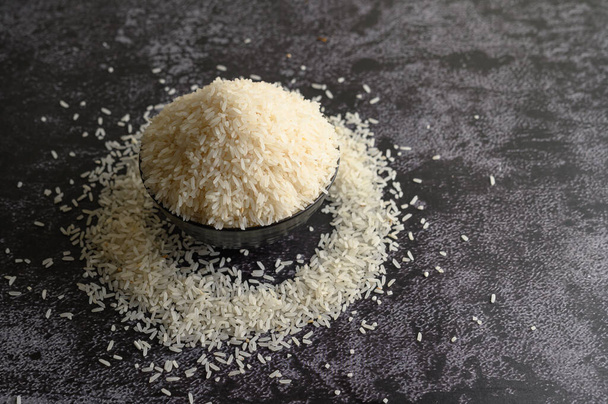 Jauhettu riisi mustassa kulhossa mustalla sementtilattialla. Valikoiva painopiste - Valokuva, kuva