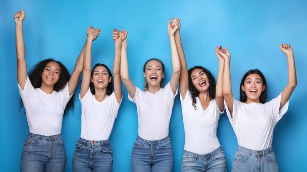 Multicultural Women Holding Raised Hands Posing Over Blue Background, Panorama - Фото, зображення