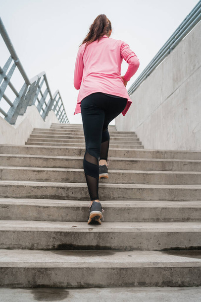 Portrait of a sport woman running on stairs outdoors. Fitness, sport and healthy lifestyle concepts. - Foto, Imagen