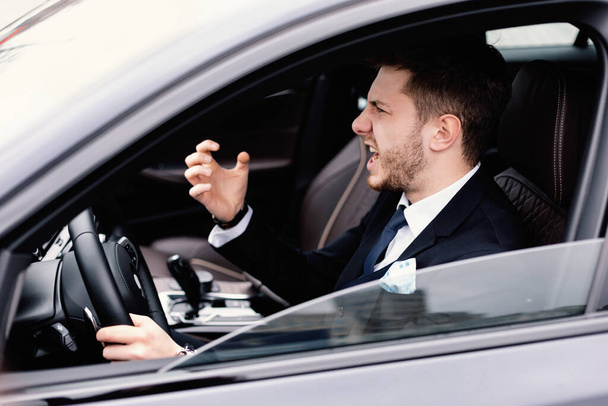 Mad young businessman driving alone in his new car - Φωτογραφία, εικόνα
