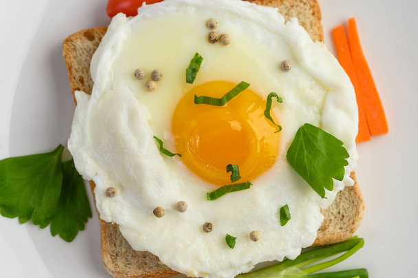 Smažené vejce na přípitku s pepřovými semínky s mrkví a jarní cibulí. - Fotografie, Obrázek