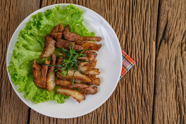 Grilled pork neck on a white plate on a wooden table - Photo, Image