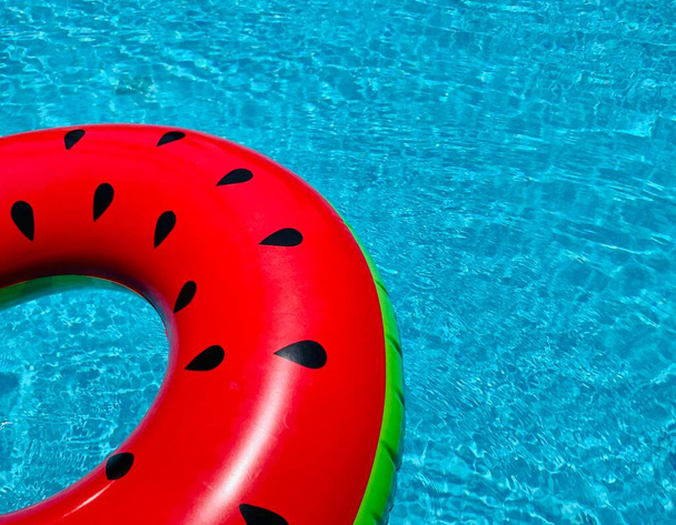 Бассейн с арбузом, кольцо, плавающее в освежающем голубом бассейне
 - Фото, изображение