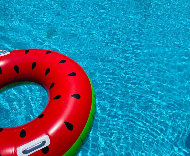 Flotador de la piscina de sandía, anillo flotando en una refrescante piscina azul
 - Foto, imagen