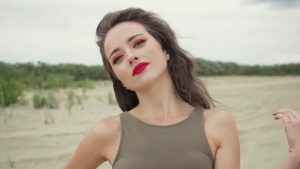 Όμορφη γυναίκα αγγίζει τα μαλλιά στην παραλία - Πλάνα, βίντεο