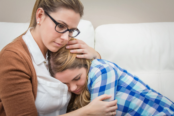 Mutter umarmt und beruhigt depressive Tochter - Foto, Bild