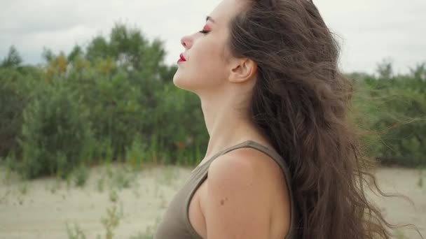 Ładna kobieta dotykająca włosów na plaży - Materiał filmowy, wideo