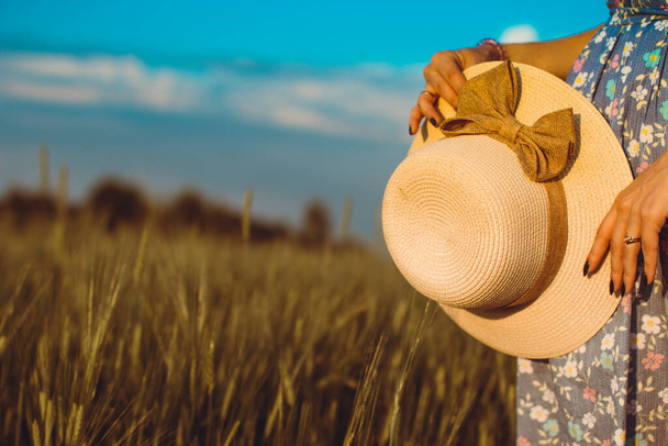 Una niña camina en verano en un campo donde crece el centeno o el trigo. Ella sostiene un sombrero en sus manos. 3.
 - Foto, imagen
