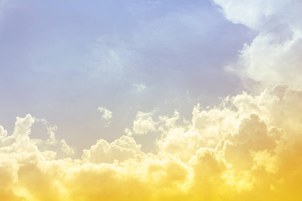 helder gele kleur in blauwe lucht met pluizige wolken - Foto, afbeelding