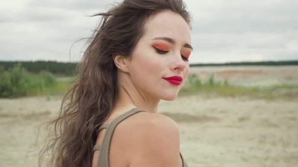Ładna kobieta dotykająca włosów na plaży - Materiał filmowy, wideo