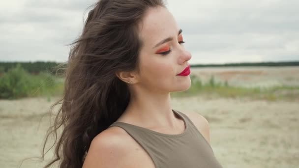 Pretty woman touching hair on beach - Footage, Video