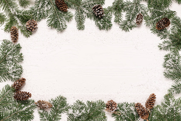 Karácsonyi háttér sablon reklám képeslapok. Bolyhos zöld lucfenyő ágak bélelt keret egy fehér fa háttér. Vízszintes keret lapos elrendezése. Karácsonyi újévi koncepció - Fotó, kép