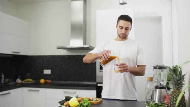 Man is pouring fresh juice into a jar - Photo, Image