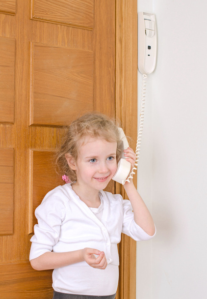 Petite fille parlant sur l'interphone à la maison
. - Photo, image