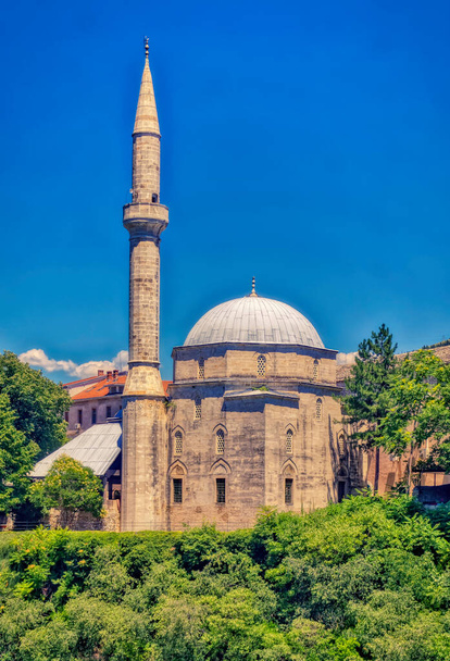 MOSTAR, BOSNIA AND HERZEGOVINA, July 01 2020: Old mosque located at bank of river Neretva in Mostar, Bosnia and Herzegovina. - Φωτογραφία, εικόνα