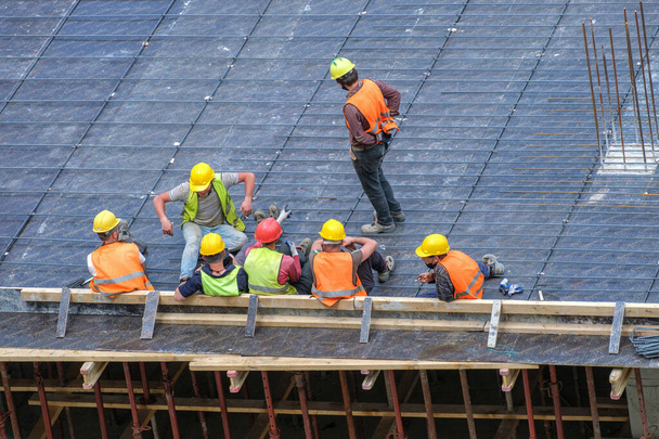 Группа рабочих на строительной площадке во время перерыва
 - Фото, изображение
