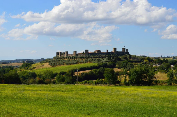 A horizontal shot of the Monteriggioni walled town located in Tuscany, Italy during daylight - Photo, Image