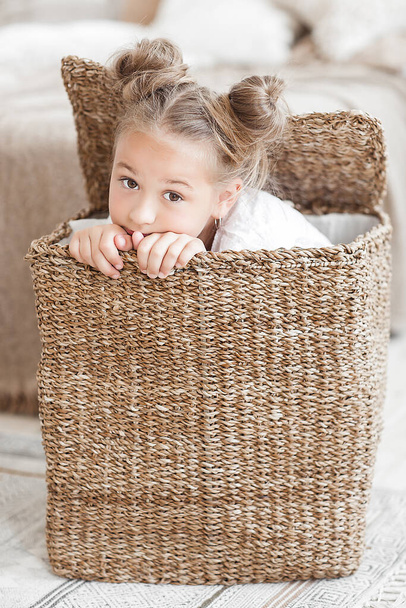 Cute funny little girl close up portrait. Child in the basket - Foto, afbeelding