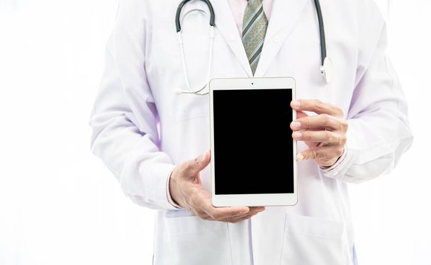 γιατρός κρατά ένα λευκό smartphone πίσω, δείχνει πληροφορίες σχετικά με κενό smartphone με ένα copyspace για να κάνουν τις δημόσιες σχέσεις διαφημίσεις δημοφιλής στα νοσοκομεία. - Φωτογραφία, εικόνα