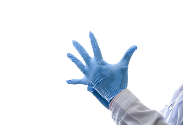 Los médicos usan guantes para prevenir infecciones antes de la cirugía en el hospital para el tratamiento de enfermedades transmisibles.
. - Foto, imagen