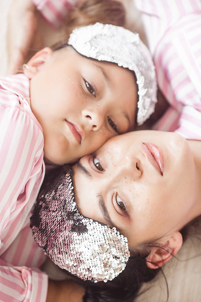 Мать и дочь спят. Симпатичный ребенок в пижаме
 - Фото, изображение