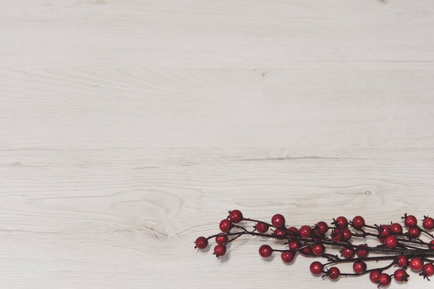 An overhead top view of a branch of red berries on a wooden background - Foto, Bild