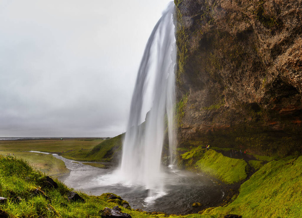 Seljalandsfoss, waterfall in the South Region in Iceland, part of the Seljalands River that has its origin in the volcano glacier Eyjafjallajokull. - Photo, Image