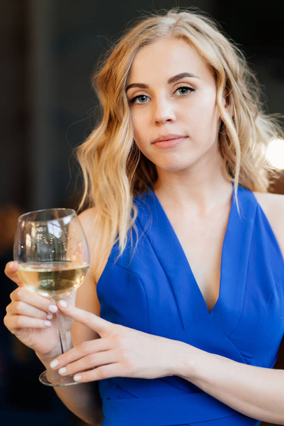 girl in blue dress standing with glass of wine. - Foto, Imagem