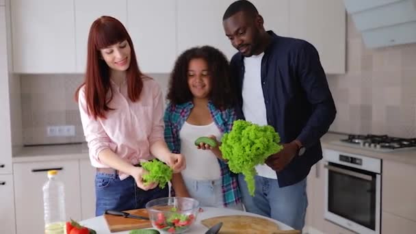 Afro-Amerikaans meisje Vanessa haar moeder en vader in de keuken het bereiden van een salade. - Video