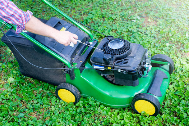 Start de grasmaaier motor in de tuin - Foto, afbeelding