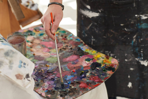 Zblízka nerozpoznatelný mužský umělec míchání barvy na paletě při malování v ateliéru, kopírování prostoru - Fotografie, Obrázek
