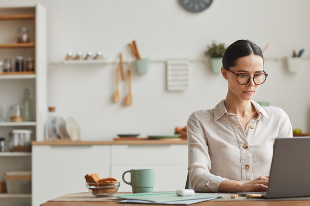 Portré elegáns fiatal nő visel szemüveg használata közben laptop kényelmes otthoni irodai munkahely, másolás tér - Fotó, kép