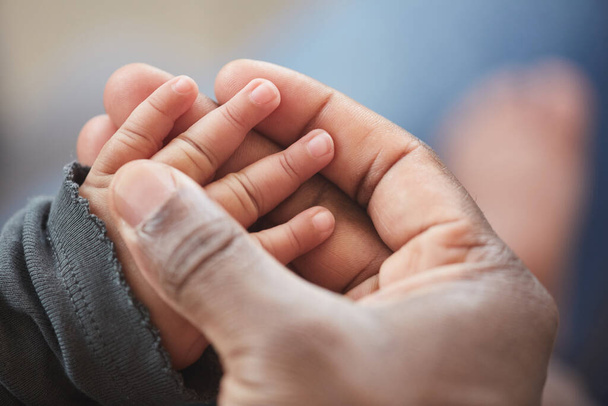 Κοντινό πλάνο του αγνώριστου Αφροαμερικανού άνδρα που κρατά το μικρό χέρι του χαριτωμένου μωρού ενώ απολαμβάνει την πατρότητα, αντίγραφο χώρου - Φωτογραφία, εικόνα